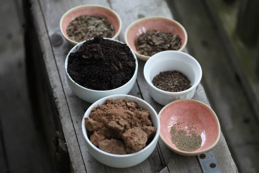 ingredients for seed balls in bowls on a wooden box