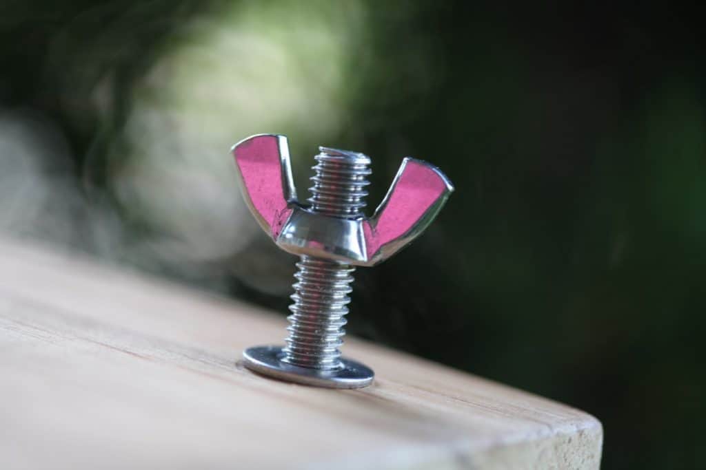 a bolt, washer and win nut attached to a piece of wood