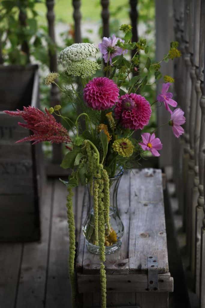 mixed farmhouse bouquet with love lies bleeding on a grey wooden crate