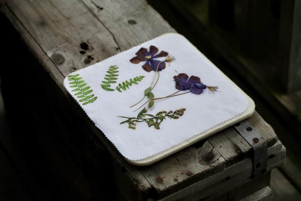 flowers and foliage pressed with the microwave press, sitting on a grey wooden box