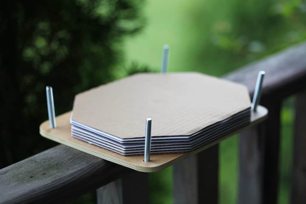 the insides of a wooden flower press with multiple layers of cardboard and paper