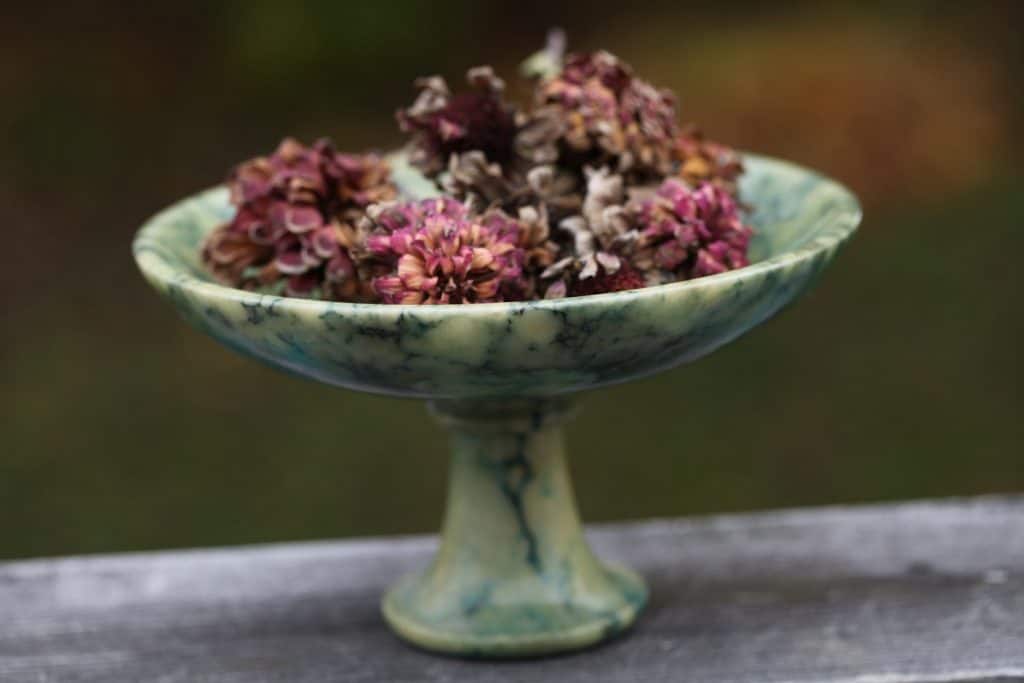 dried zinnia blooms in a green alabaster bowl