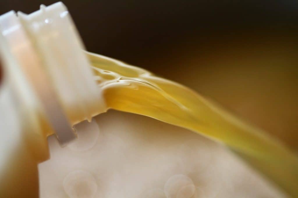 a jug spout pouring apple cider into a pot