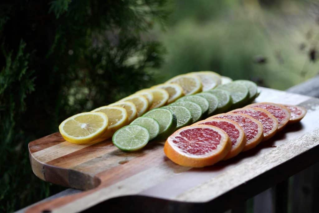 slices of lemon, lime, and grapefruit on a wooden cutting board