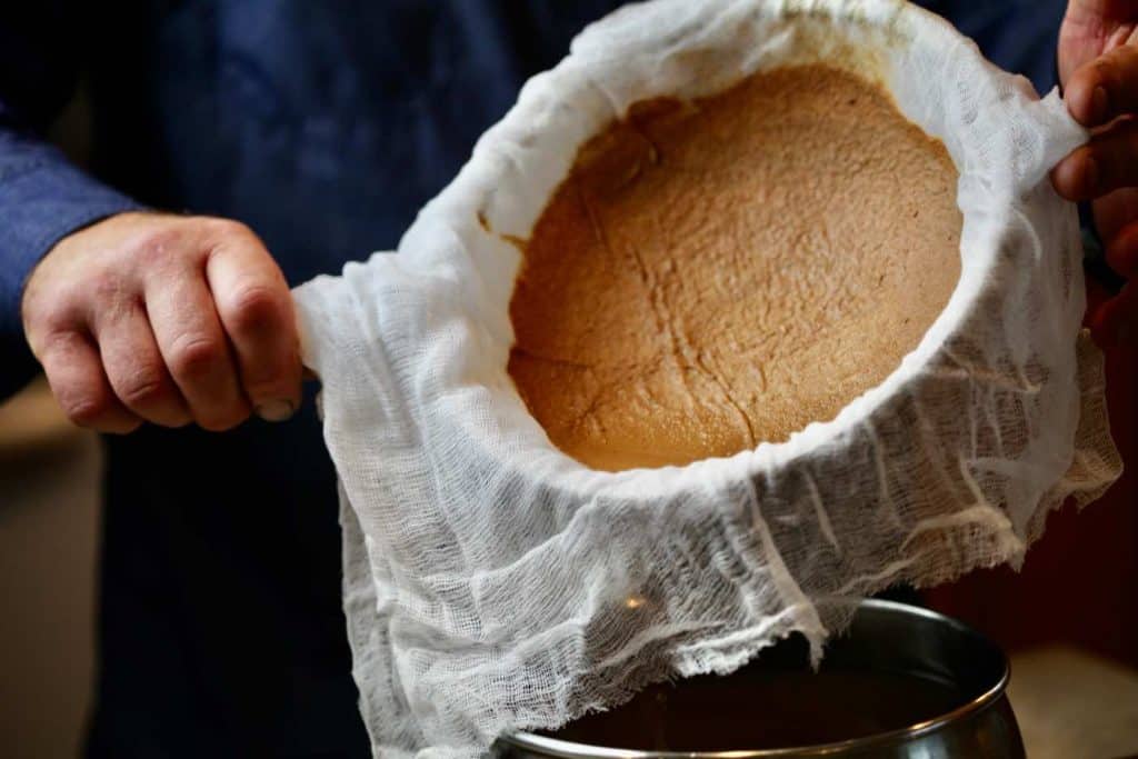 cheesecloth with brown foam strained from the apple cider