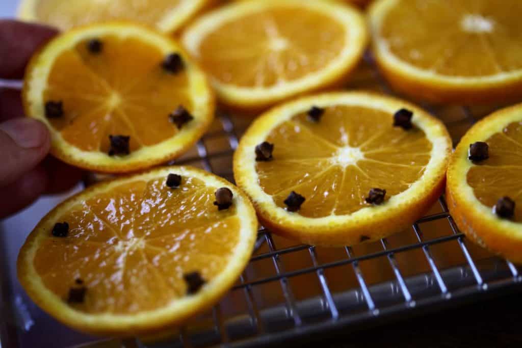 orange slices with cloves on a bakers rack