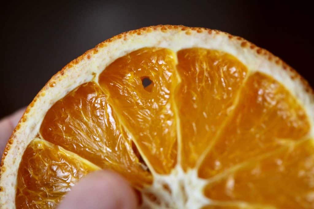 an orange slice with a small hole made to insert thread for decoration