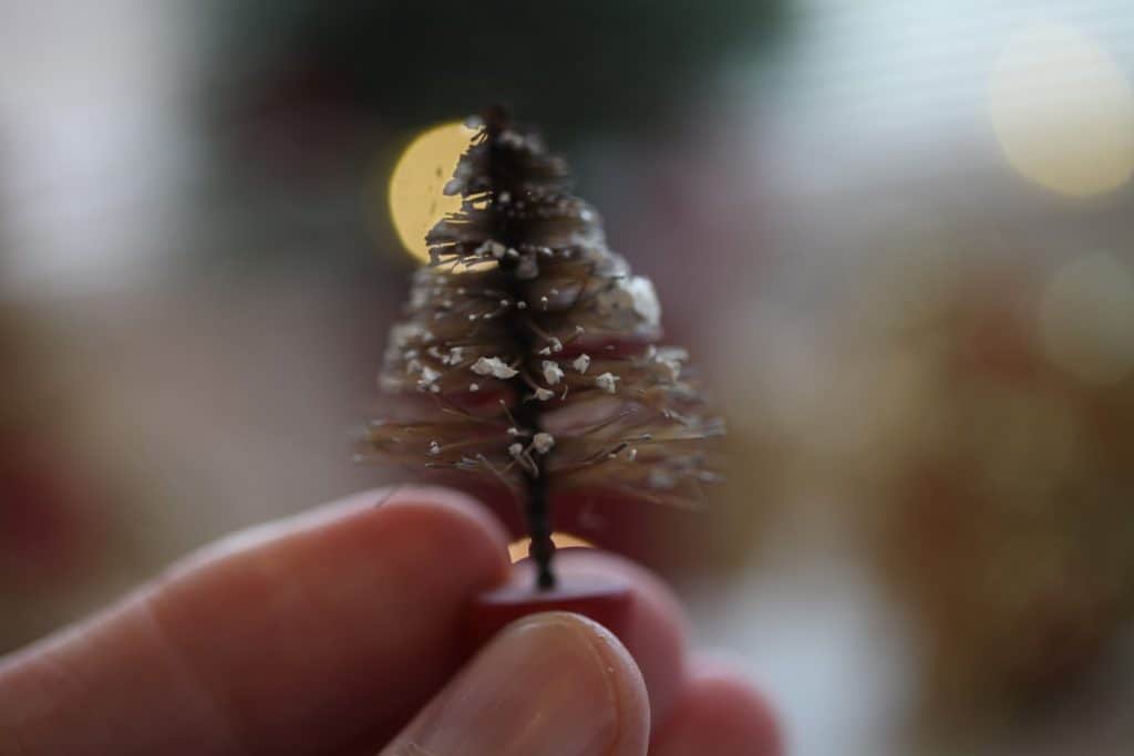 a hand holding a tiny mini vintage bottle brush tree