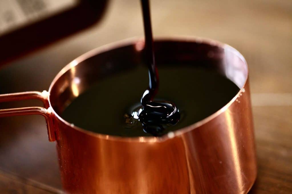 one cup of molasses, in a copper measuring cup