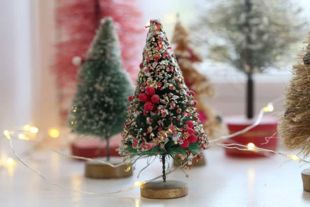 vintage bottle brush tree adorned with glitter, next to the small trees