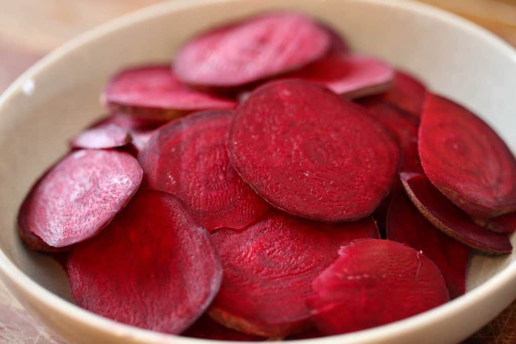 red beet slices in a bowl being prepared to make air fryer beet chips
