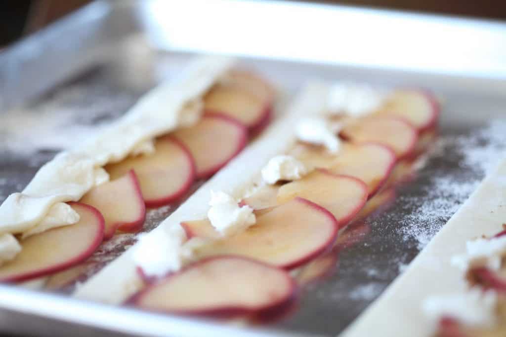 apple slices on puff pastry with dabs of cream cheese