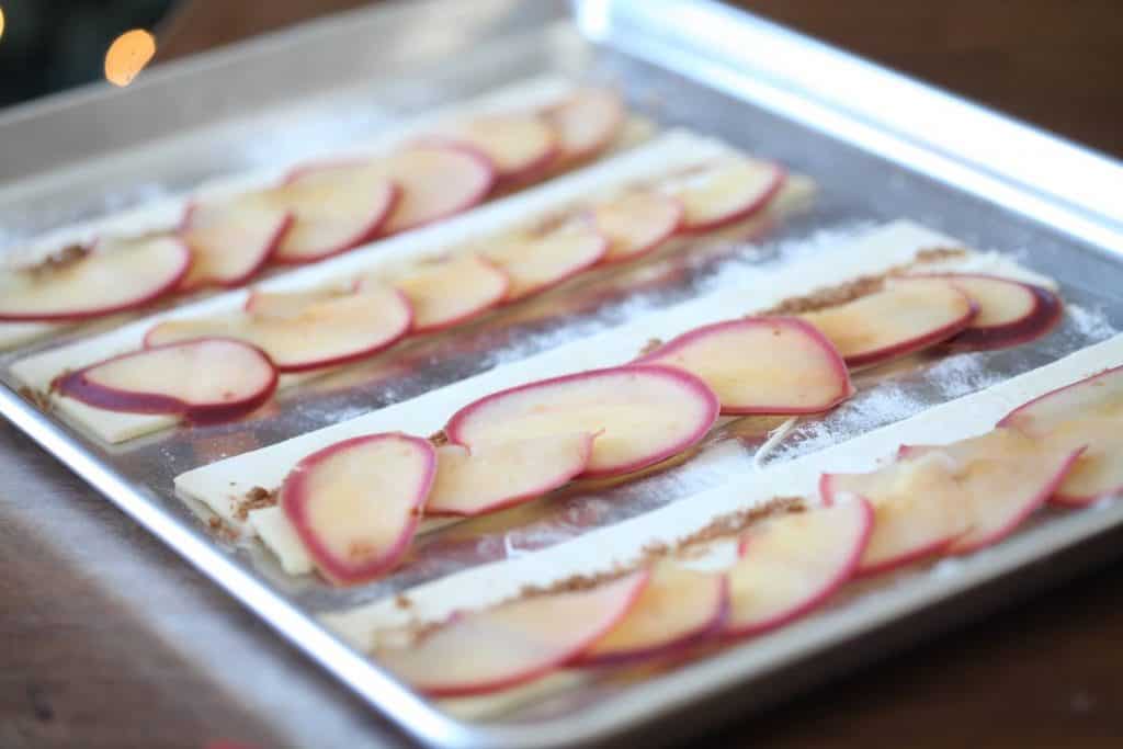 apple slices lined out on strips of puff pastry