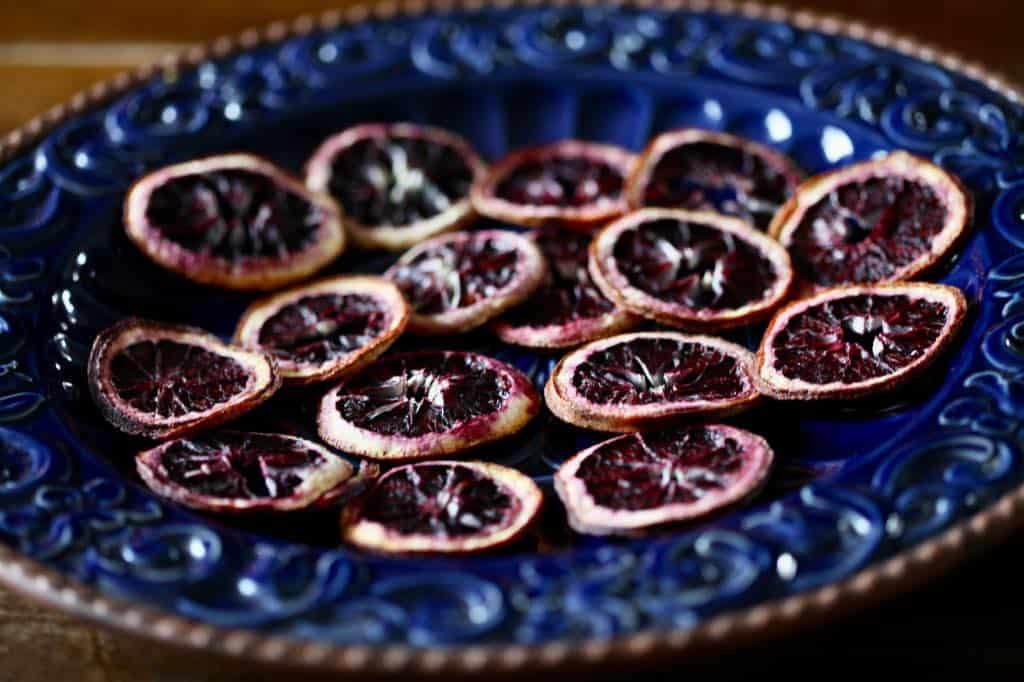 dehydrated slices of blood oranges on a blue platter