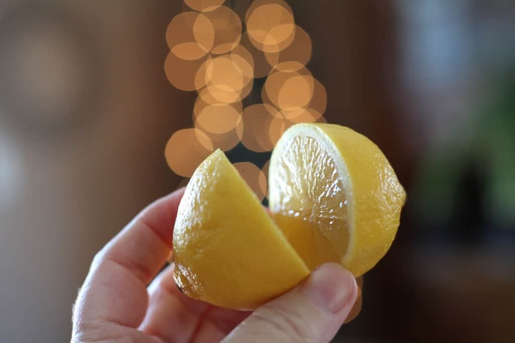 a hand holding a halved lemon