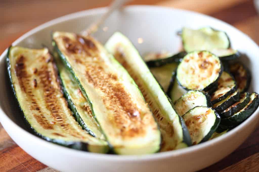 air fried zucchini with garlic in a white bowl