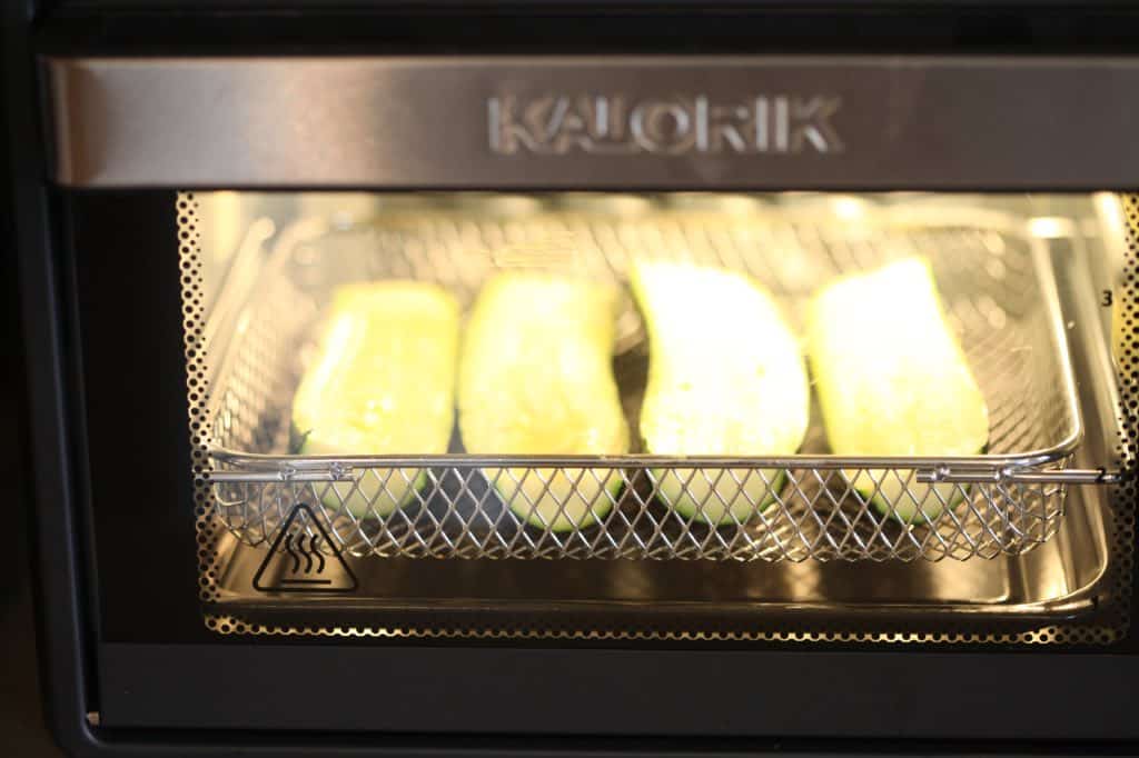 zucchini cooking in an air fryer oven