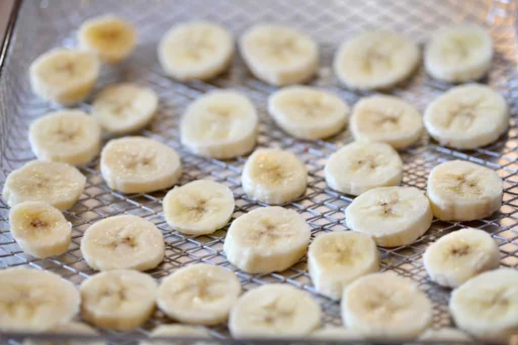 banana slices in the air fryer basket in a single layer, making dehydrated banana chips