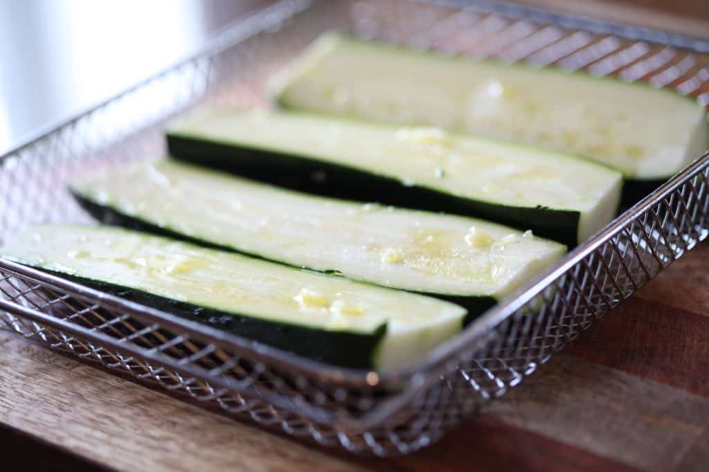 zucchini halves in the Kalorik air fryer oven basket