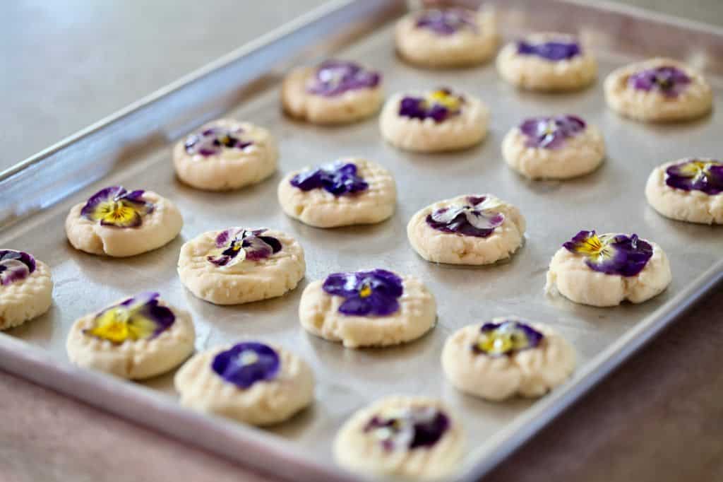 edible flower shortbread cookies on a baking sheet, ready to bake