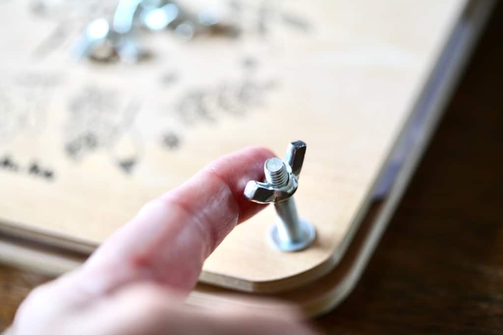 a finger touching the bolting mechanism on a store bought flower press