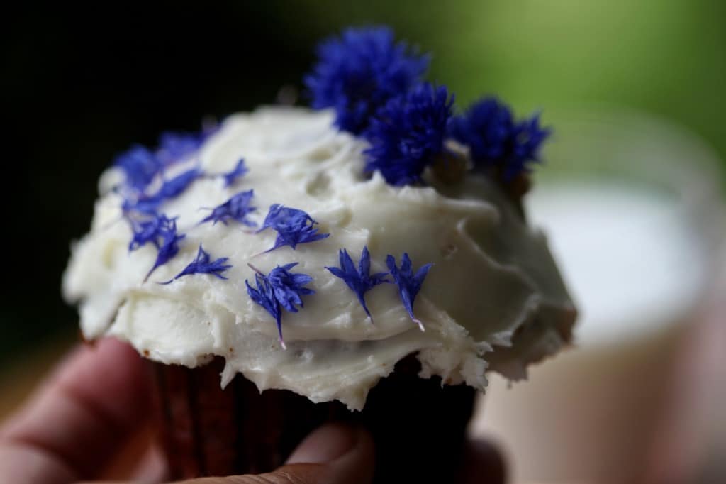 a cupcake with icing and blue flowers