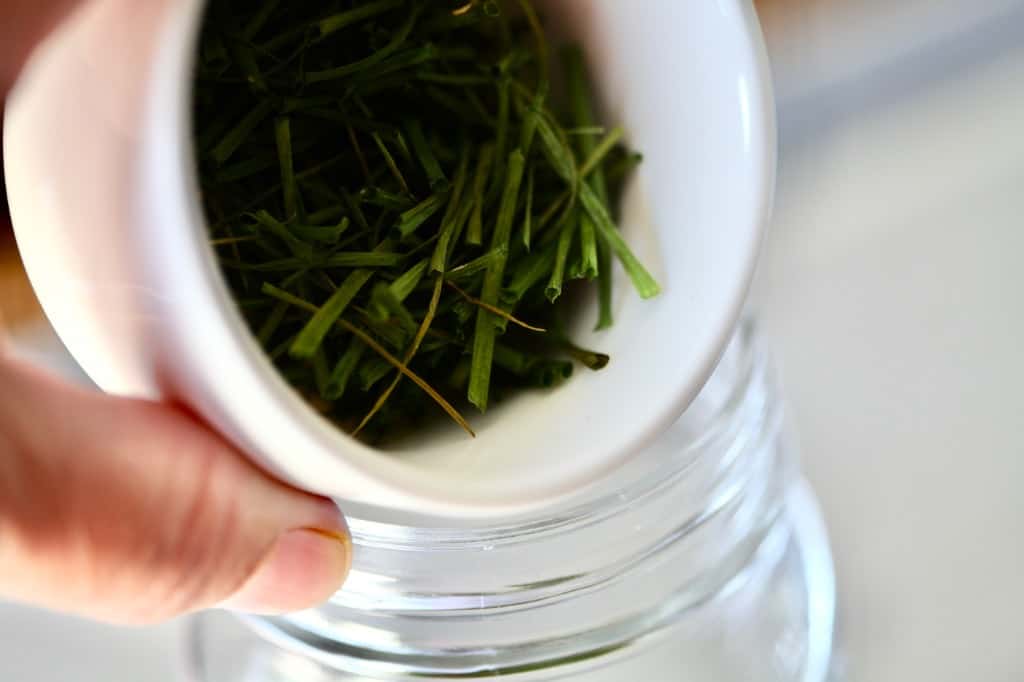 dried hives being placed in a mason jar for storage