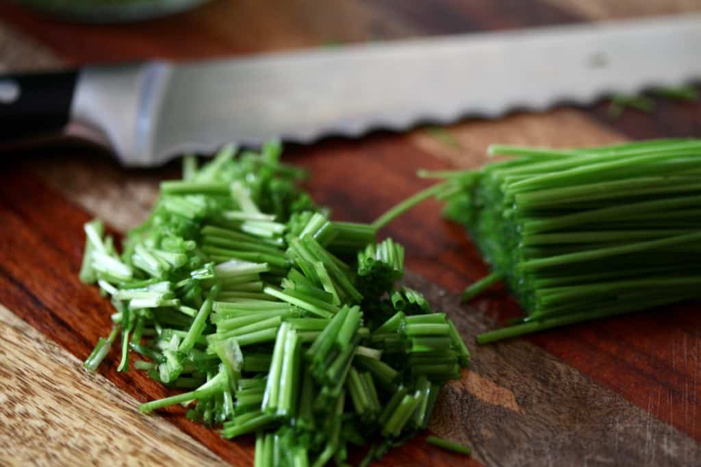 chopped chives next to a knife