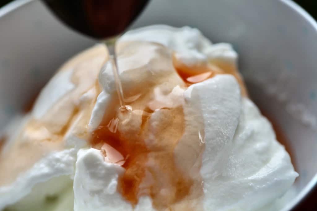 drizzling rose hip syrup over plain yogurt