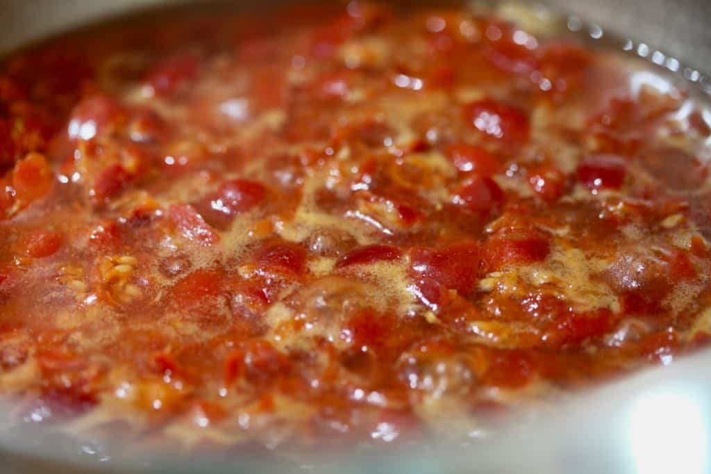simmering rose hips in a pot, making a rose hip syrup recipe