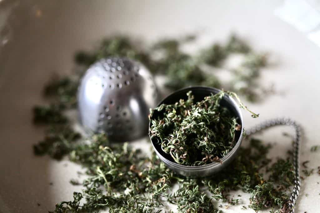 tea ball full of dried yarrow leaves, showing how to dry yarrow for tea
