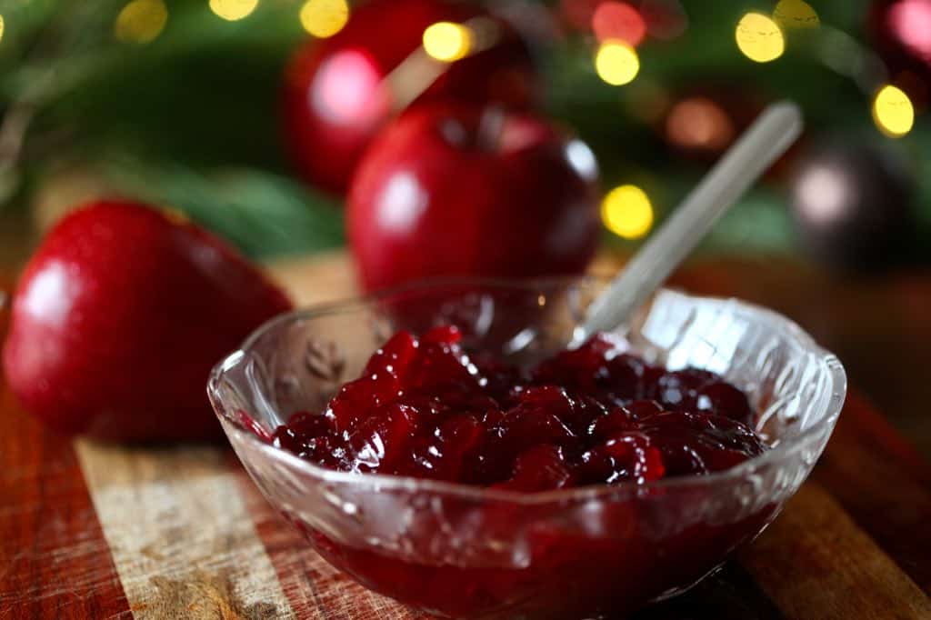 a bowl of cranberry sauce and apples, some of the ingredients for the Christmas jello recipe
