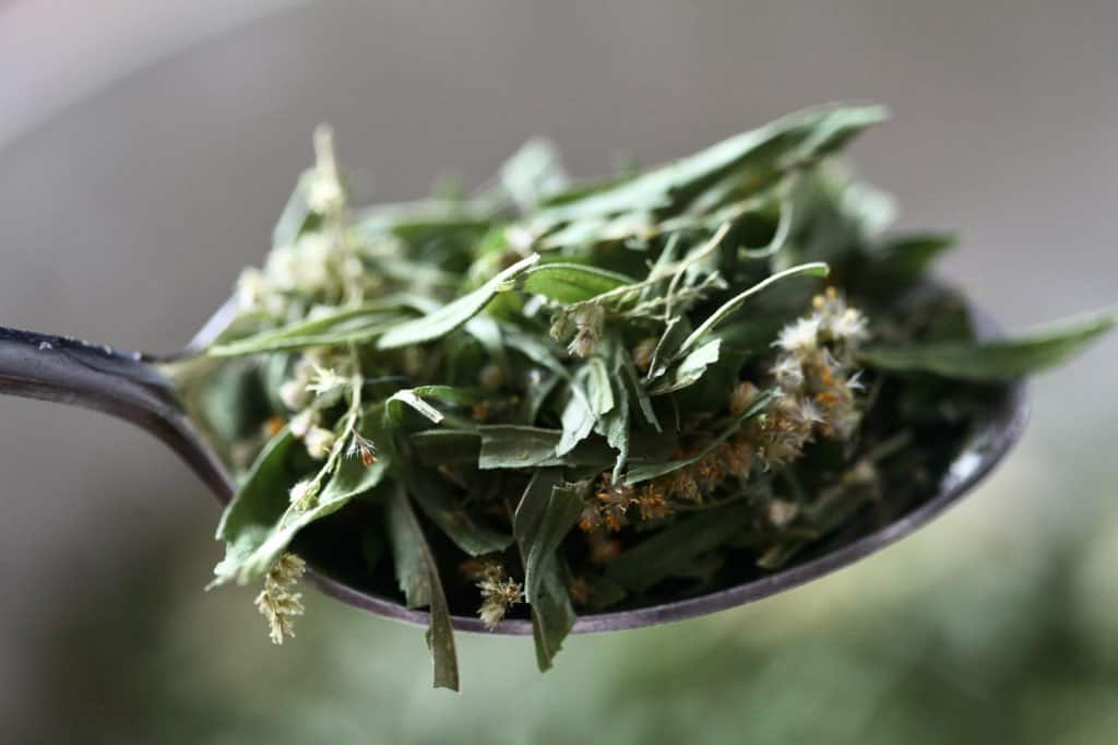 dried leaves and flowers on a spoon