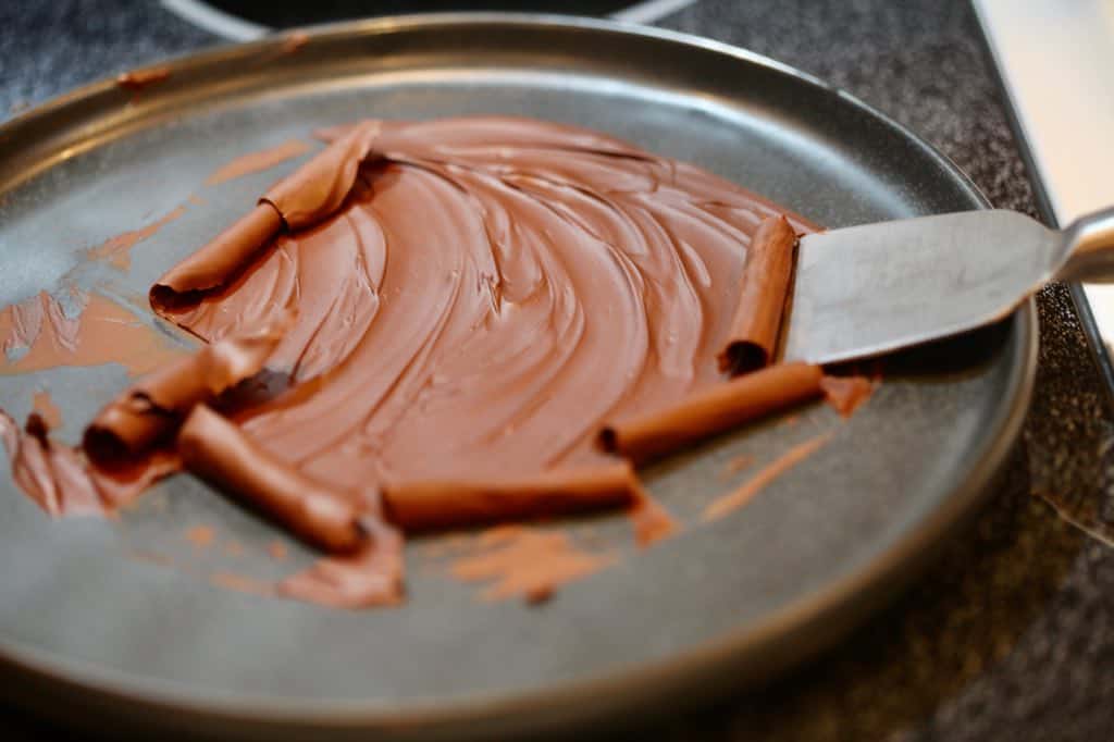 push the melted chocolate with a spatula after it hardens slightly, making thin chocolate curls