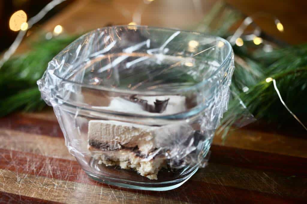 mud pie in a glass bowl covered with plastic wrap for storage