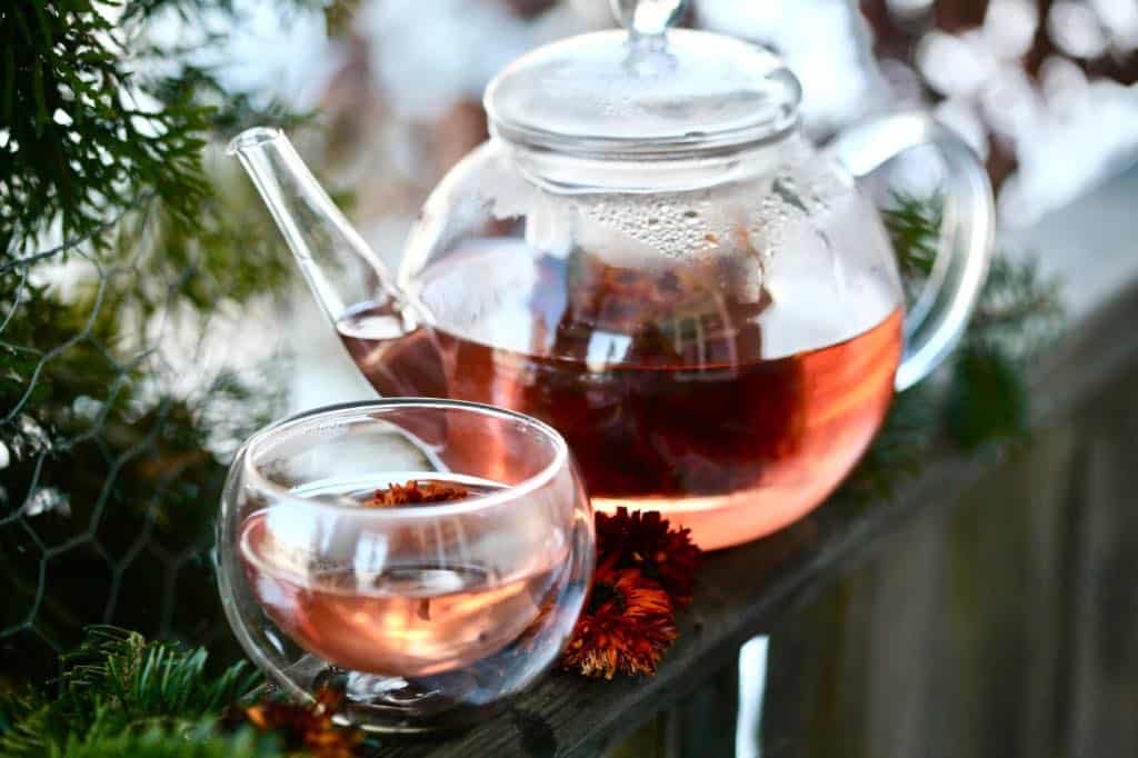 a teapot and tea cup filled with calendula tea