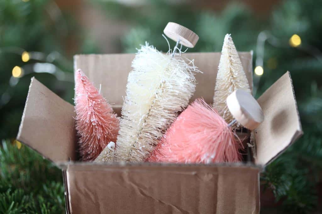 pink and white bottle brush trees stuffed into a box, demonstrating the wrong way to store the trees