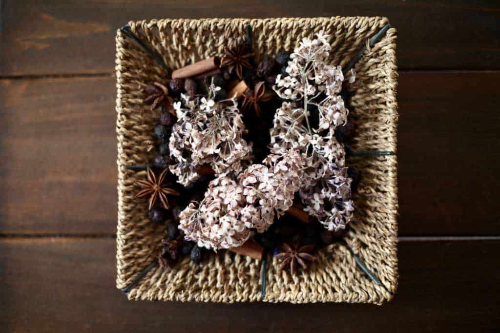 dried lilacs added to potpourri in a basket