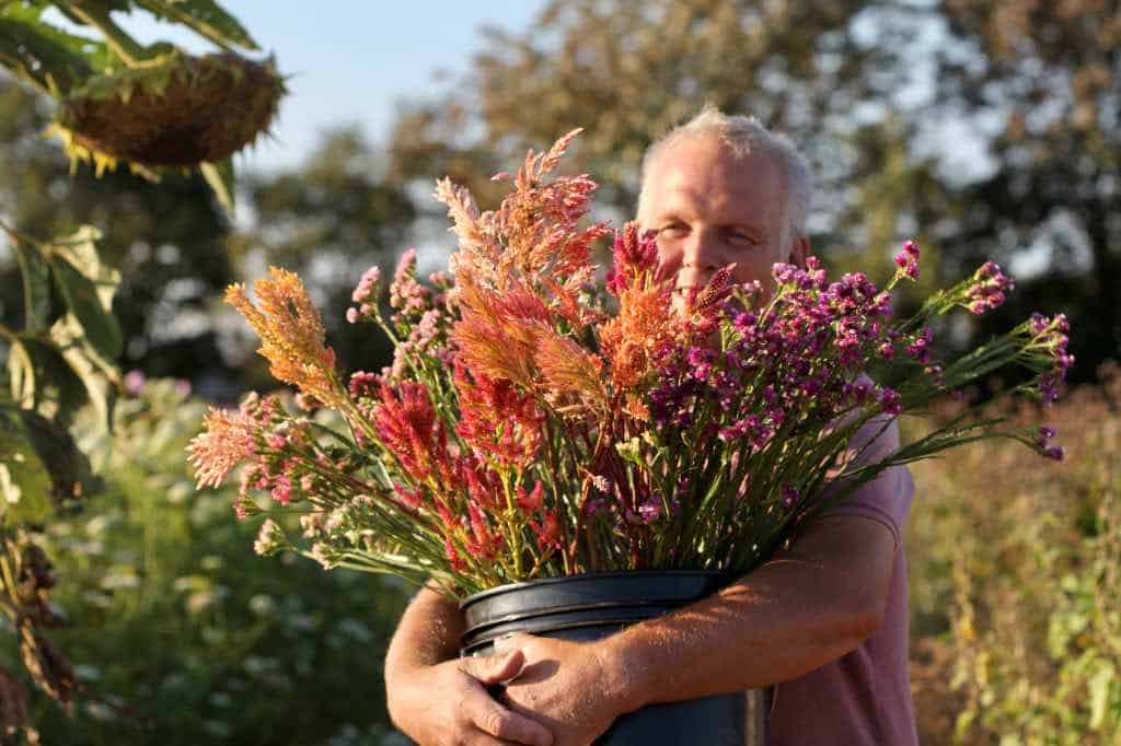 a man holding a bucket of flowers